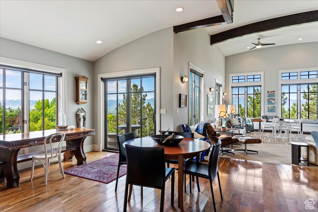 Dining space featuring beamed ceiling, high vaulted ceiling, light wood-type flooring, and ceiling fan