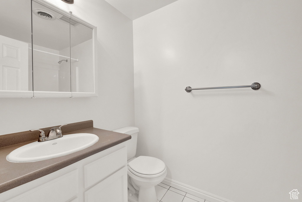 Bathroom featuring tile floors, vanity, and toilet