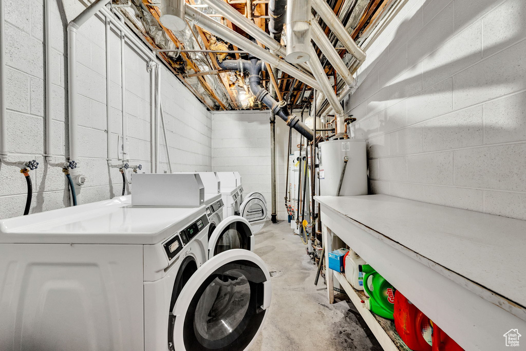 Clothes washing area featuring water heater, washer hookup, and independent washer and dryer