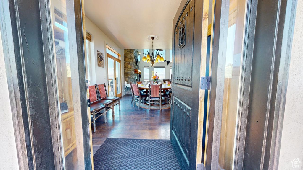 Corridor featuring dark hardwood / wood-style flooring and an inviting chandelier