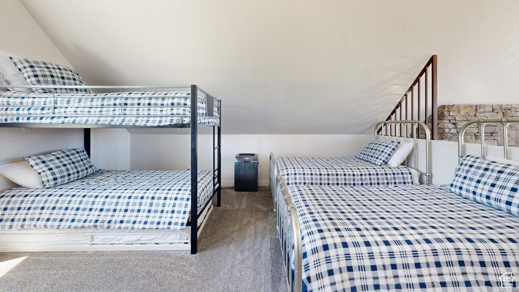 Bedroom featuring carpet flooring and lofted ceiling