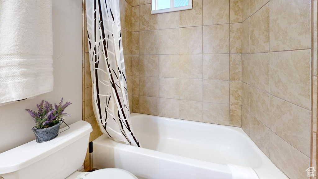 Bathroom with shower / bath combo with shower curtain and toilet