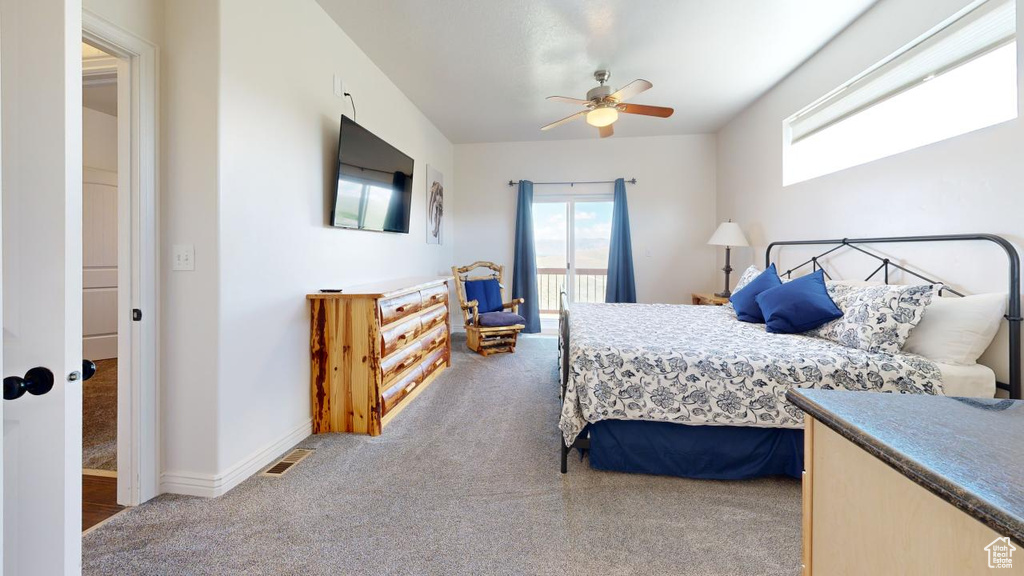 Bedroom featuring carpet, multiple windows, and ceiling fan