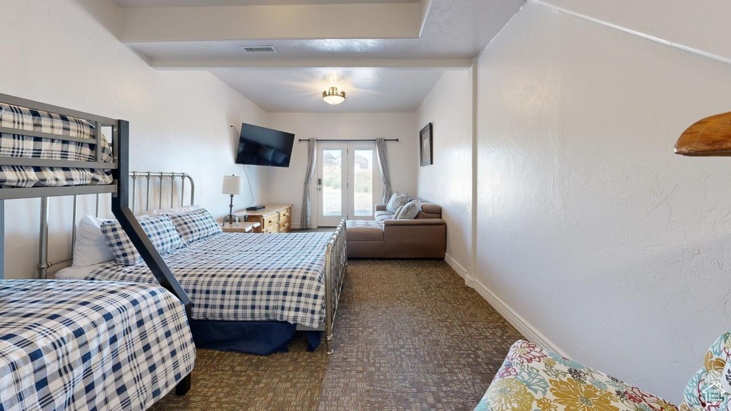 Carpeted bedroom featuring french doors