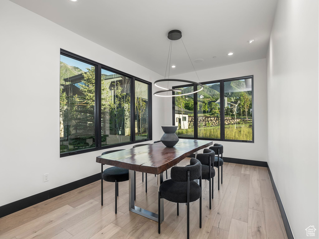 Dining area with plenty of natural light, light hardwood / wood-style flooring, and an inviting chandelier