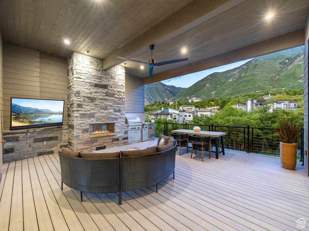 Wooden deck featuring exterior kitchen and a mountain view