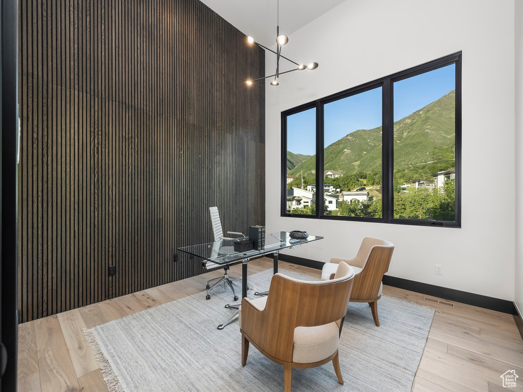 Office area featuring a chandelier, a wealth of natural light, light wood-type flooring, and a mountain view