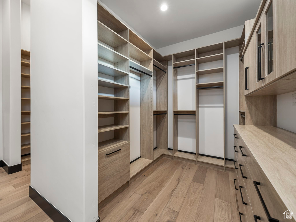 Spacious closet with light hardwood / wood-style floors