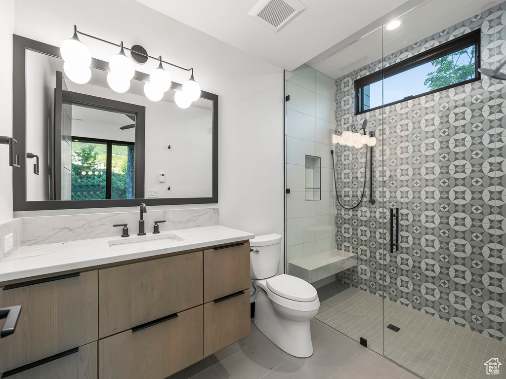 Bathroom with walk in shower, tile flooring, oversized vanity, and toilet