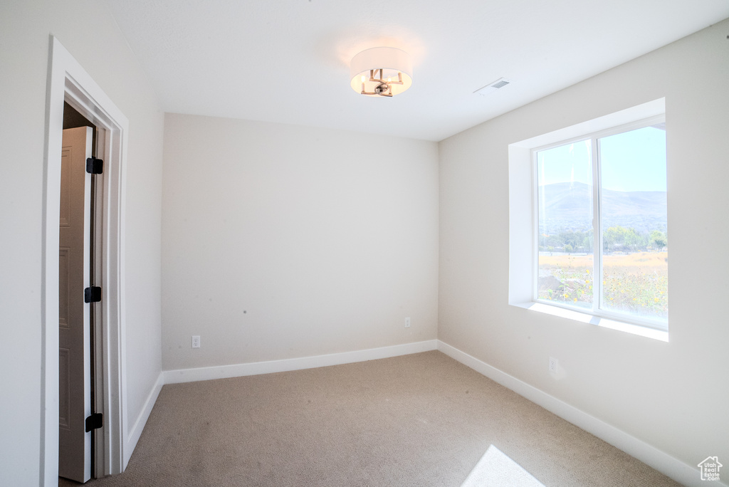 Empty room featuring carpet and a mountain view