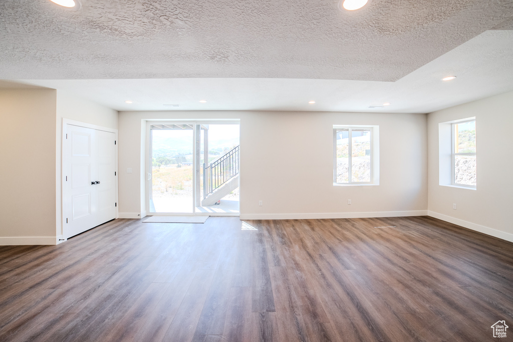 Unfurnished room featuring a textured ceiling and dark wood-type flooring