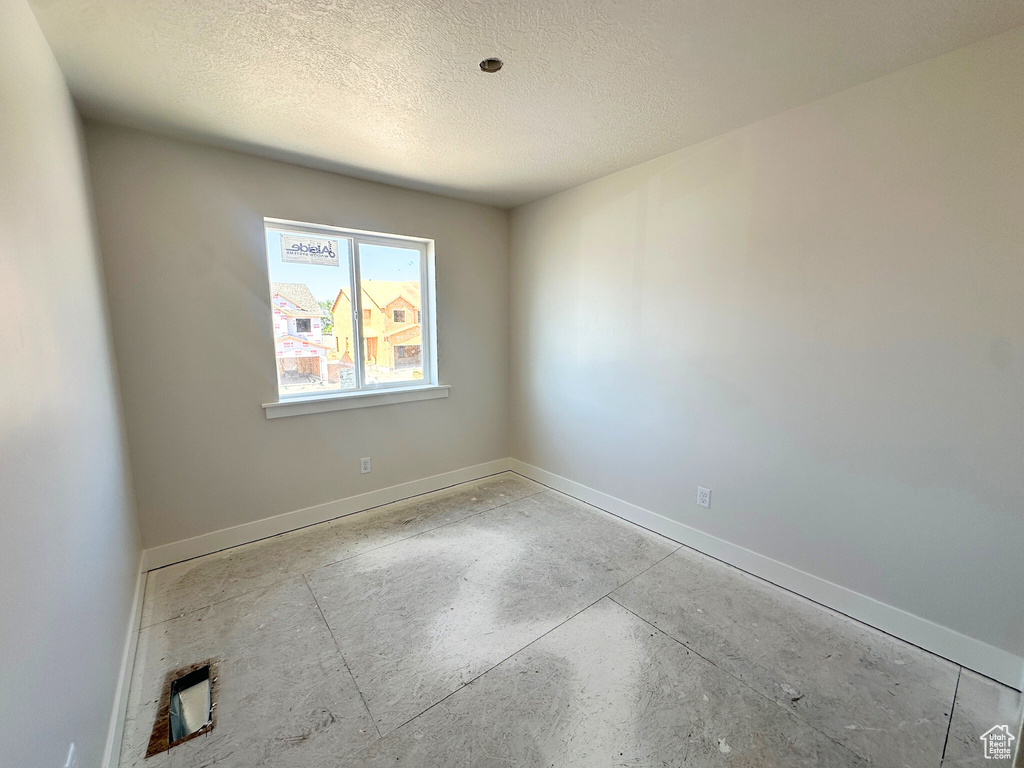 Unfurnished room with a textured ceiling