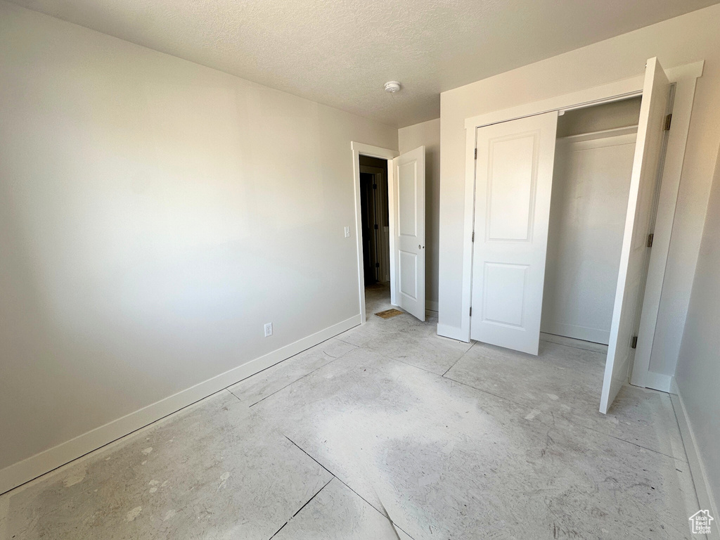 Unfurnished bedroom with a textured ceiling and a closet