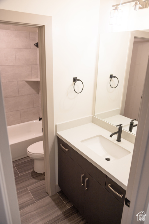 Full bathroom with vanity, toilet, and tiled shower / bath