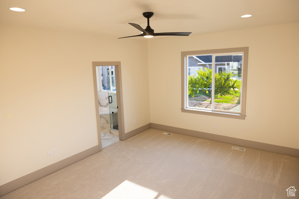 Carpeted spare room with ceiling fan