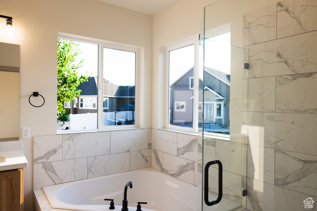 Bathroom featuring vanity and separate shower and tub