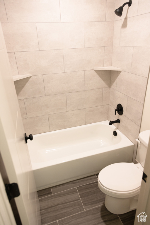 Bathroom featuring toilet and tiled shower / bath combo