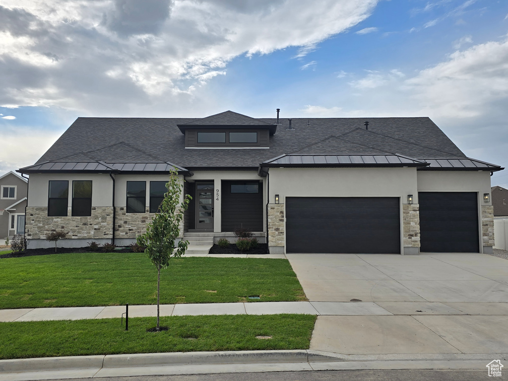 Prairie-style house featuring a front lawn and a garage