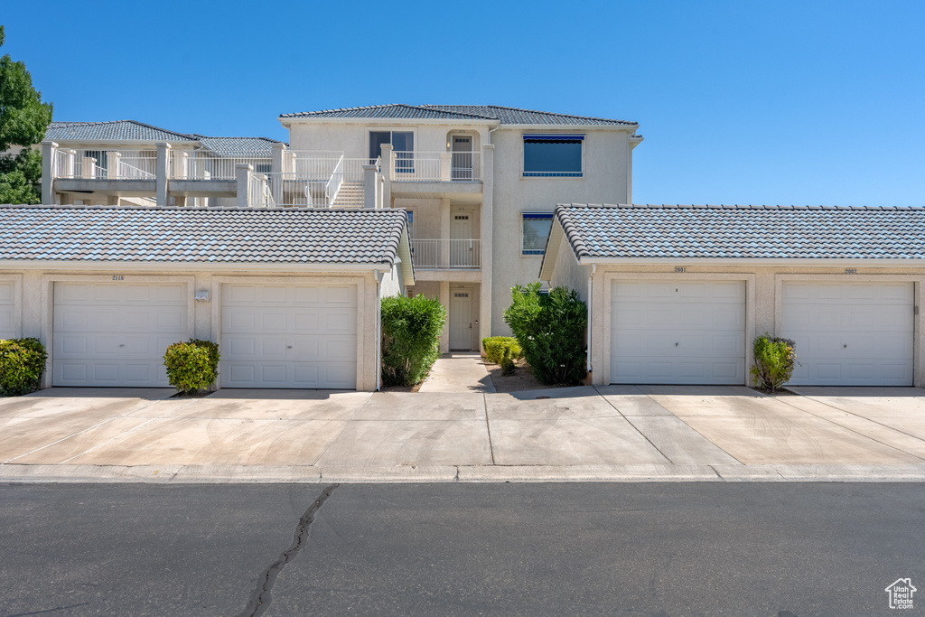 View of front of property with a garage and a balcony