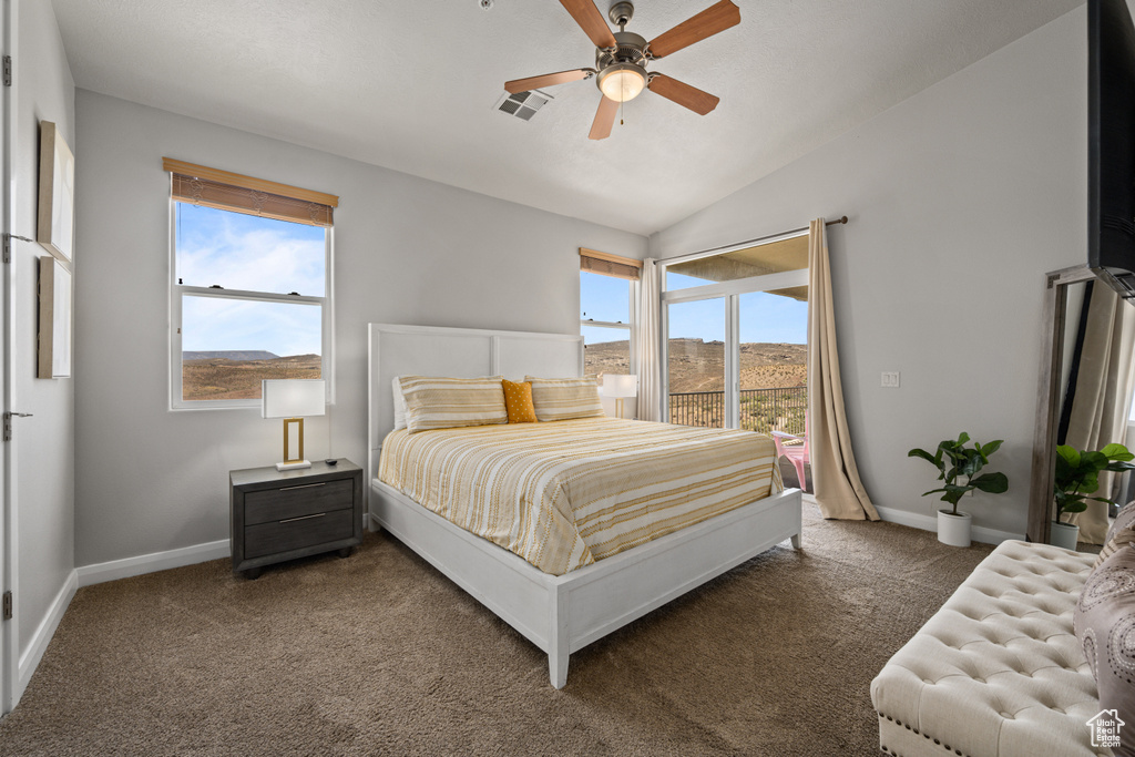 Carpeted bedroom with ceiling fan and lofted ceiling