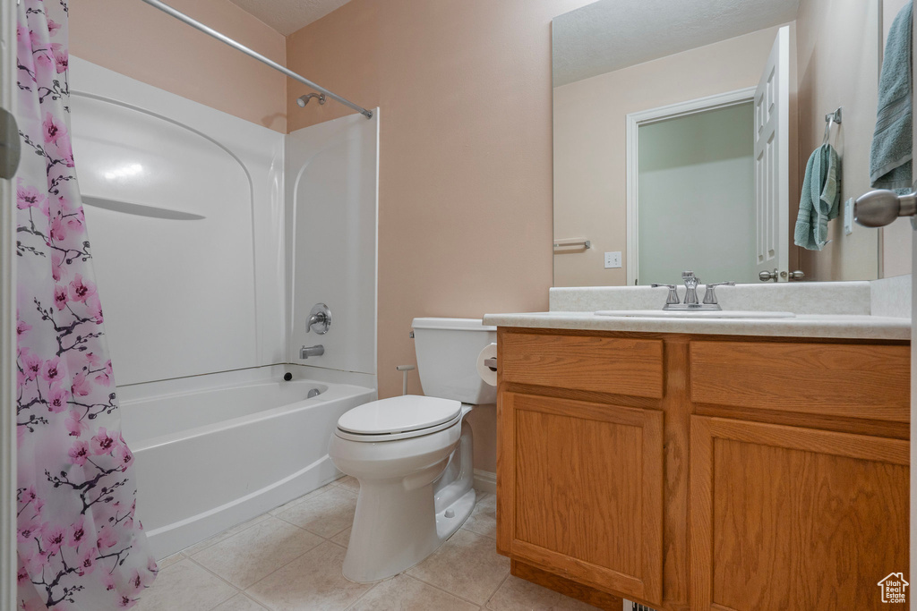 Full bathroom featuring shower / bathtub combination with curtain, tile flooring, vanity, and toilet