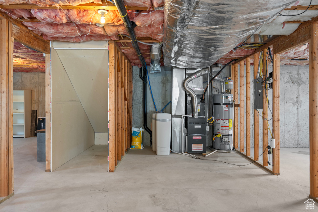 Basement featuring strapped water heater