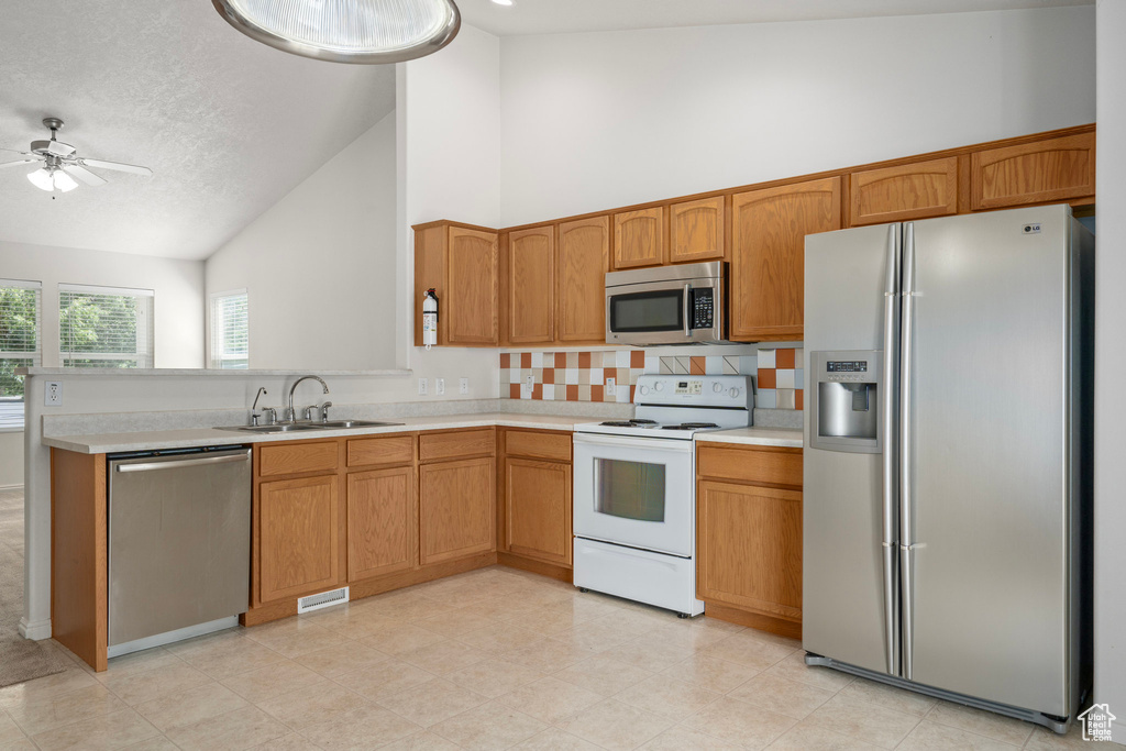 Kitchen with ceiling fan, light tile floors, high vaulted ceiling, sink, and appliances with stainless steel finishes