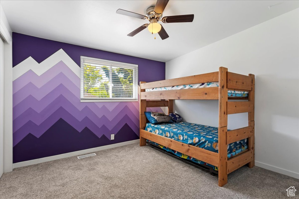 Carpeted bedroom featuring ceiling fan