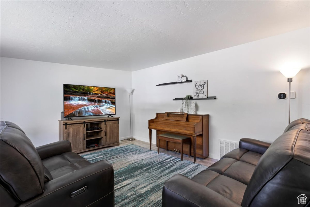 Living room with hardwood / wood-style flooring and a textured ceiling