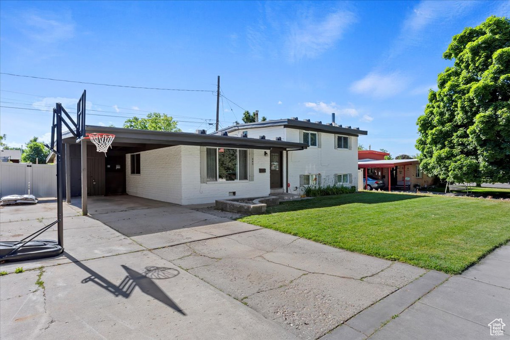 View of front of home featuring a carport and a front lawn