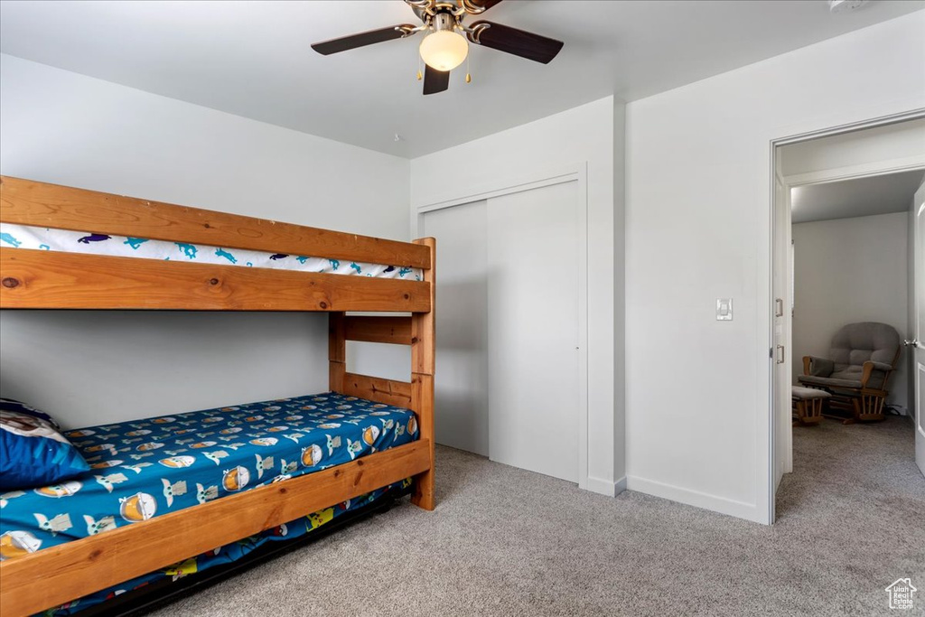 Carpeted bedroom with a closet and ceiling fan