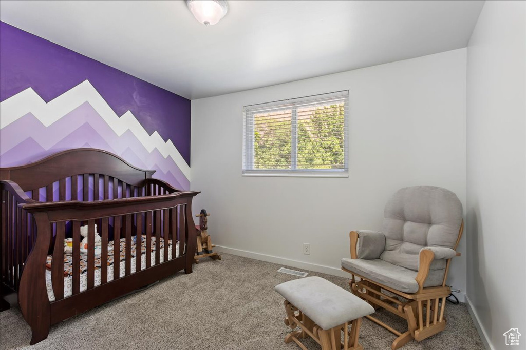 Carpeted bedroom featuring a nursery area