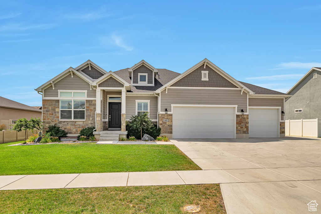 Craftsman inspired home featuring a garage and a front yard