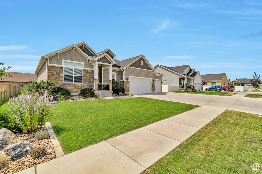 Craftsman house with a front lawn and a garage