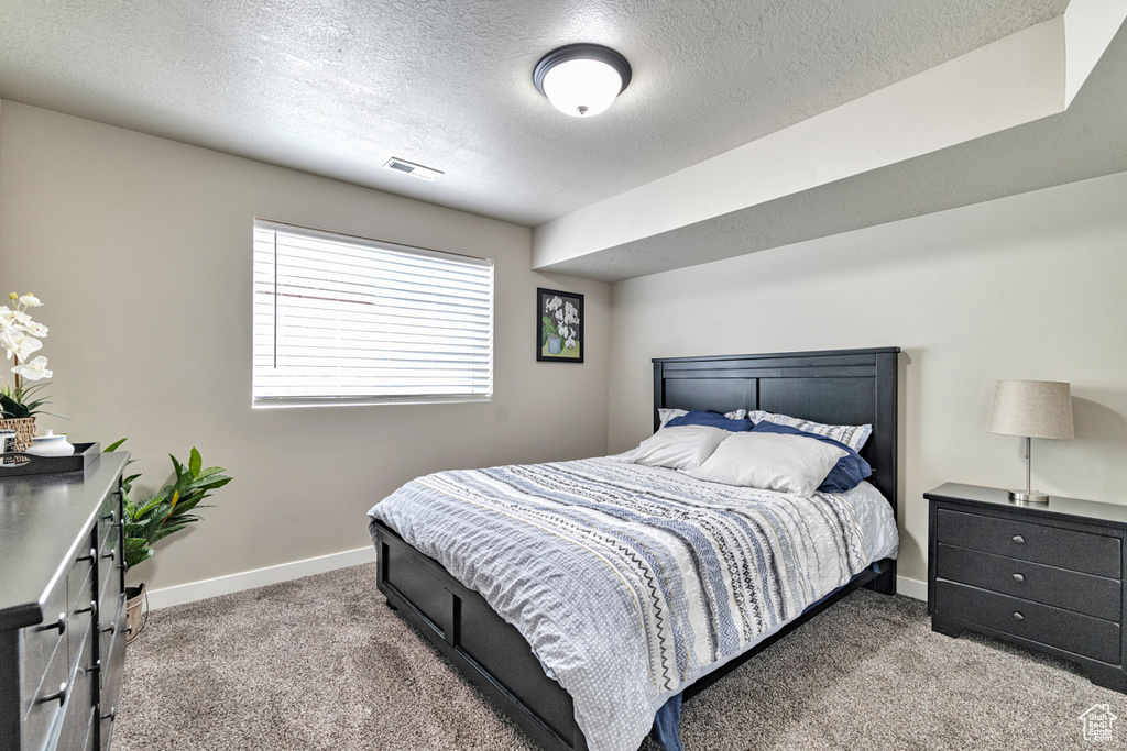 Bedroom featuring a textured ceiling and carpet