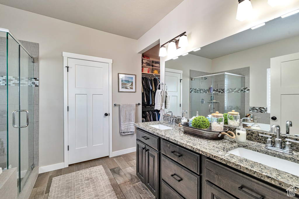 Bathroom with walk in shower, hardwood / wood-style flooring, and double vanity