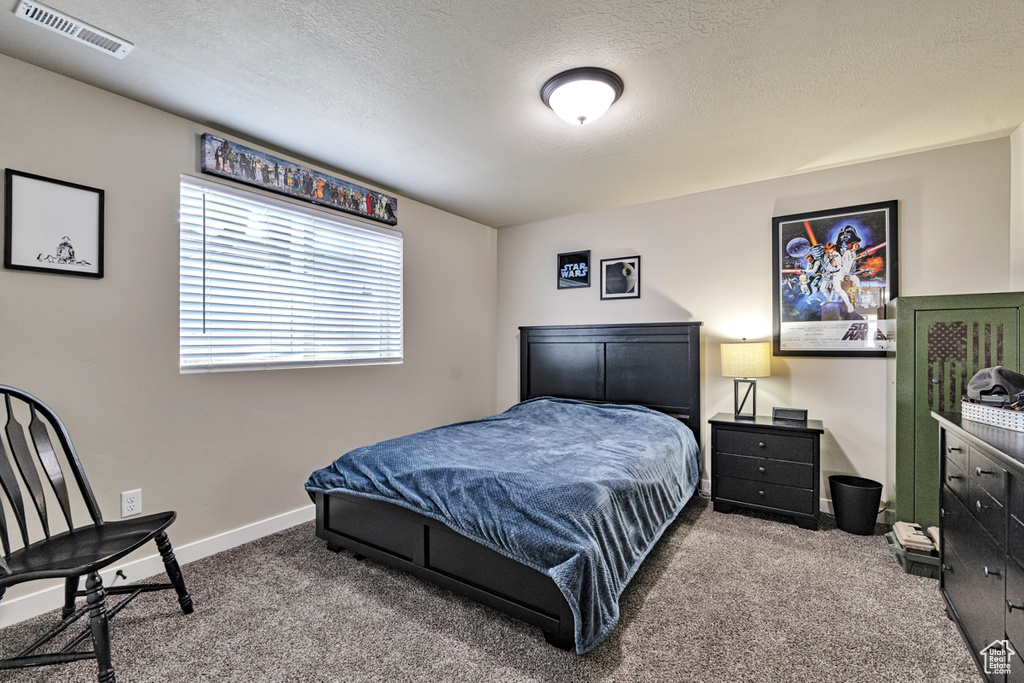 Carpeted bedroom featuring a textured ceiling