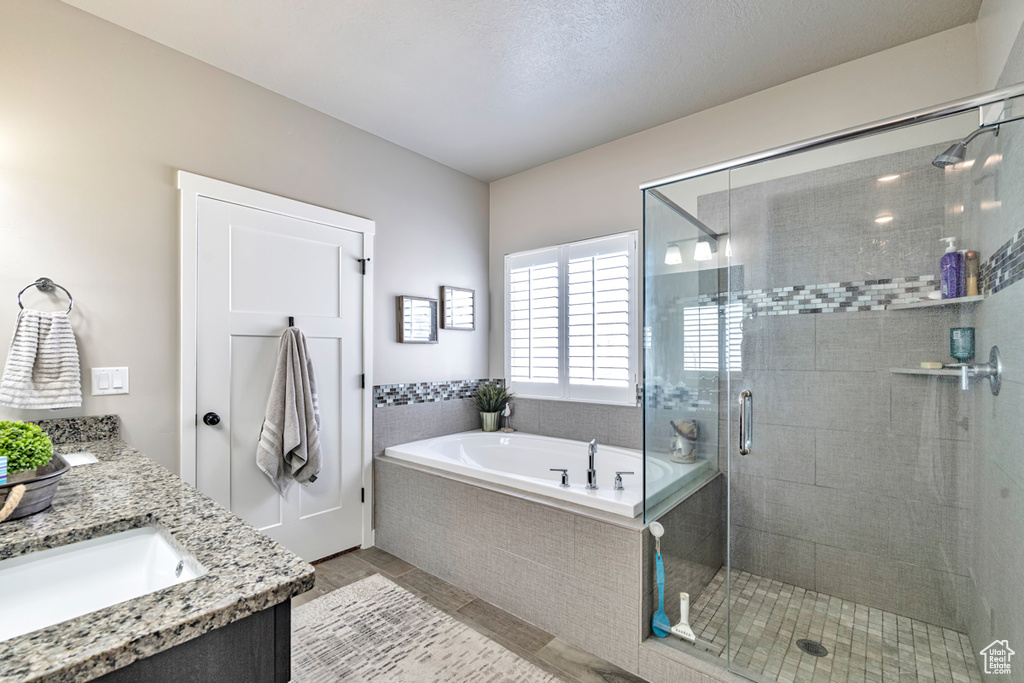 Bathroom featuring tile floors, a textured ceiling, independent shower and bath, and vanity