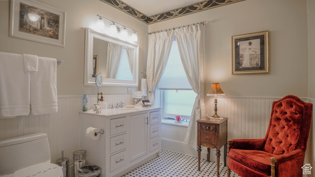 Bathroom featuring tile flooring, toilet, and vanity with extensive cabinet space