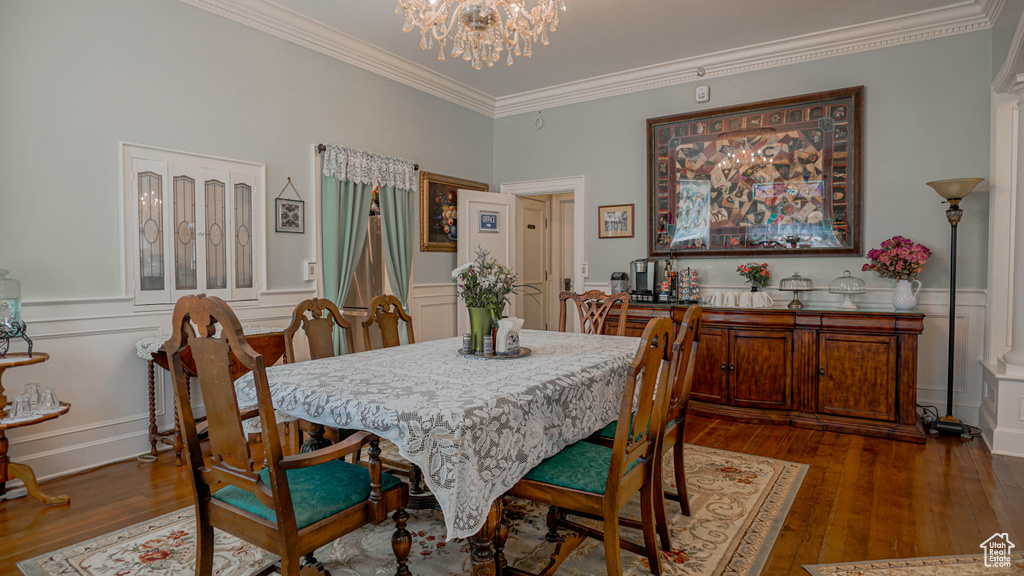 Dining area featuring a chandelier, ornamental molding, and dark hardwood / wood-style floors