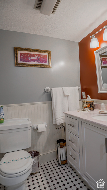 Bathroom featuring tile flooring, vanity, and toilet