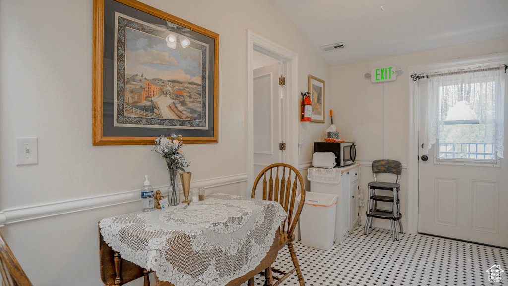 Dining space featuring vaulted ceiling and light colored carpet