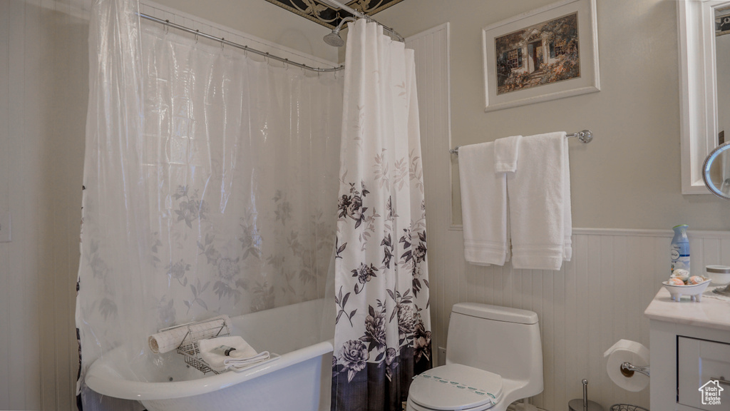 Full bathroom featuring shower / bath combination with curtain, toilet, and vanity