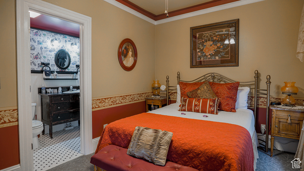 Bedroom featuring dark carpet, sink, and ornamental molding