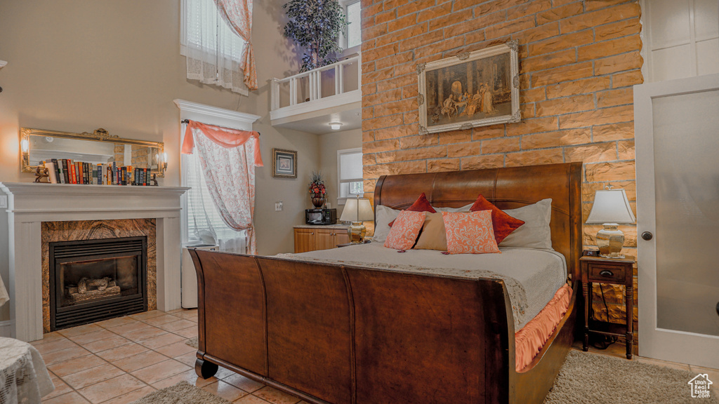 Bedroom with a fireplace and light tile floors