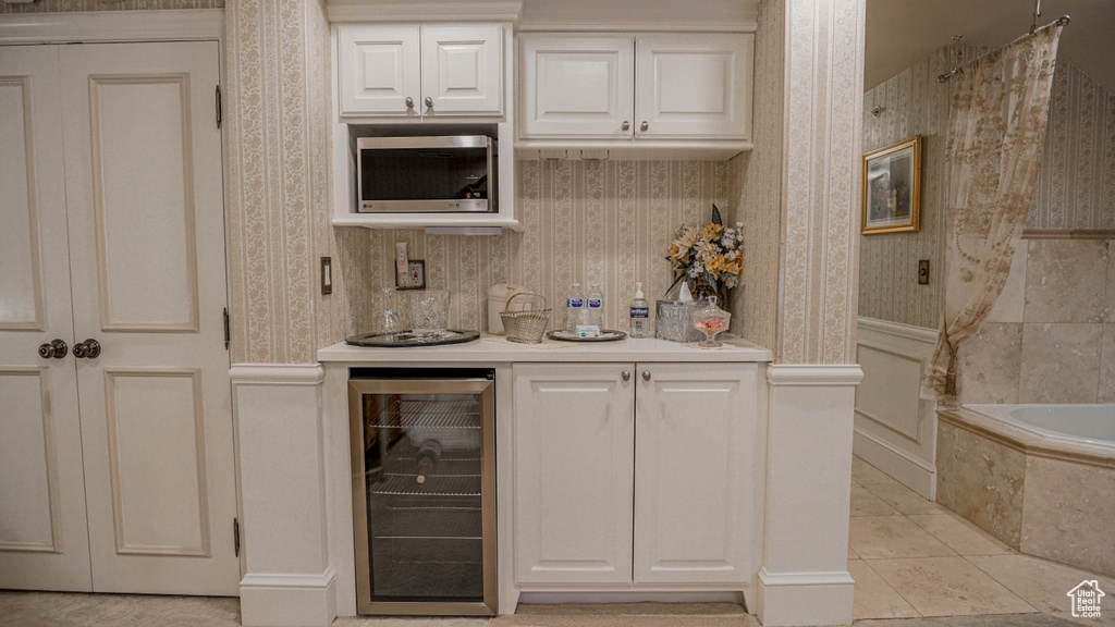 Interior space featuring white cabinets, light tile flooring, and beverage cooler