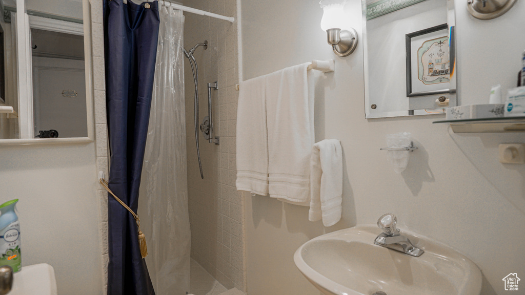 Bathroom featuring sink and a shower with shower curtain