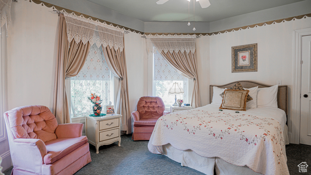 Bedroom featuring ceiling fan and dark colored carpet