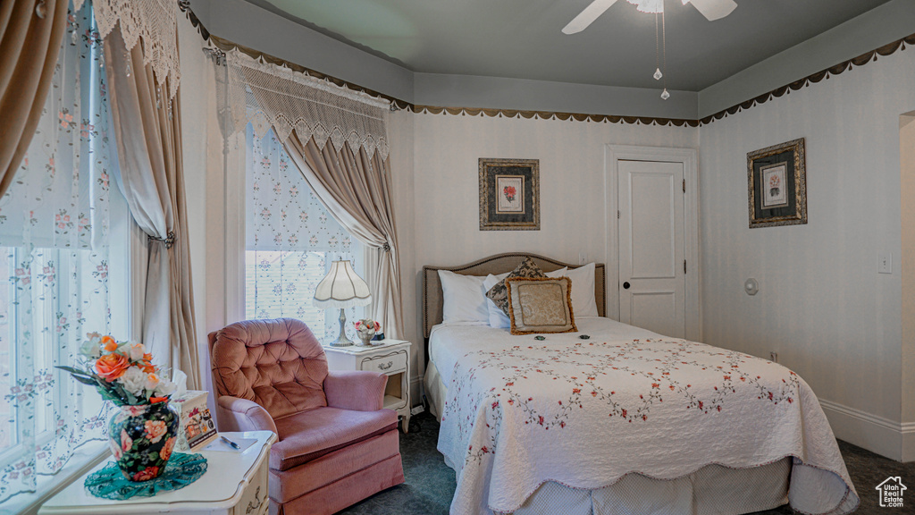 Carpeted bedroom featuring ceiling fan