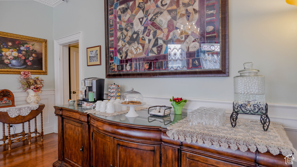 Interior space with wood-type flooring, light stone countertops, and crown molding